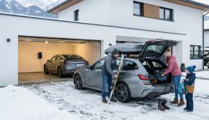Rodzina pakuje samochód na zimowy wyjazd w góry – porównanie auta elektrycznego i spalinowego na ferie