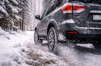 napęd 4x4 zimą – samochód z napędem na cztery koła jadący po zaśnieżonej leśnej drodze w zimowych warunkach