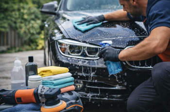 Mężczyzna wykonujący wiosenny detailing czarnego samochodu