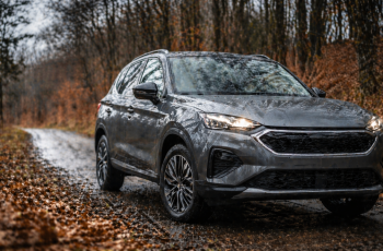 nowoczesny suv na mokrej leśnej drodze jesienią