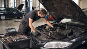 Mechanik sprawdzający silnik używanego samochodu w warsztacie