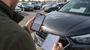 Osoba sprawdzająca dokumenty i numer VIN podczas sprowadzania auta z zagranicy