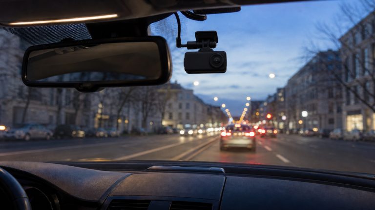 Wideorejestrator zamontowany przy lusterku wstecznym w samochodzie