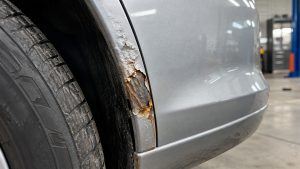 Korozja samochodu rozwijająca się na krawędzi nadkola