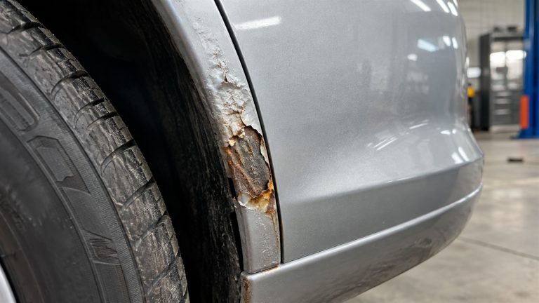Korozja samochodu rozwijająca się na krawędzi nadkola